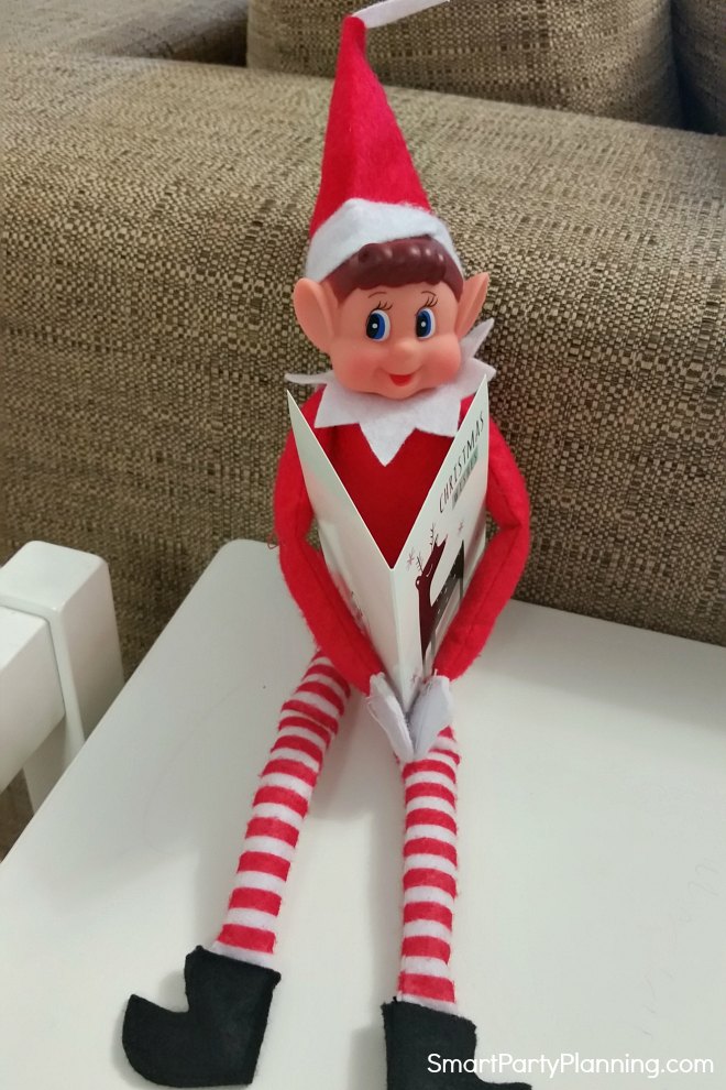 elf on the shelf reads a Christmas card elf on the shelf reads a Christmas card