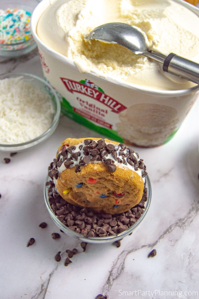 Cover ice cream sandwich in topping of choice